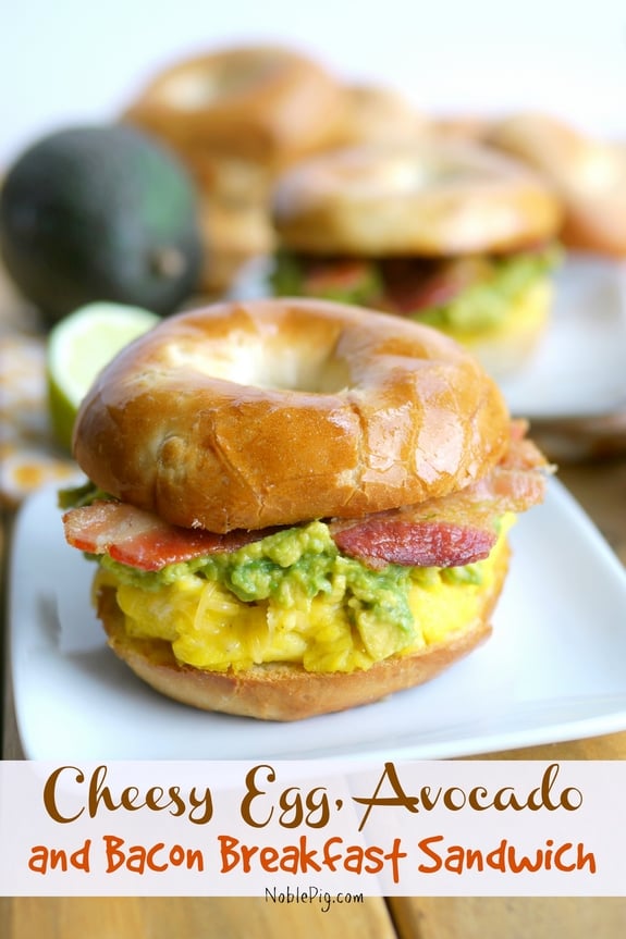 Cheesy Egg Avocado and Bacon Breakfast Sandwich on a white plate with text on photo that says, Cheesy egg, avocado and bacon breakfast sandwich.