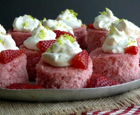 VIDEO + RECIPE: A Daiquiri mixer and tequila give these Strawberry Margarita Cakes Bites their namesake. The lime zested whipped cream flecked with sea salt is reminiscent of a salted rim on a margarita glass from NoblePig.com #noblepig #Boozydessert #margarita #strawberrydessert #strawberry