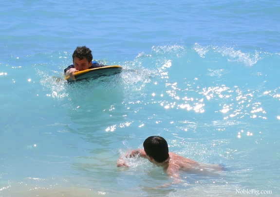 Boys riding the waves on Waikiki Beach Hawaii.