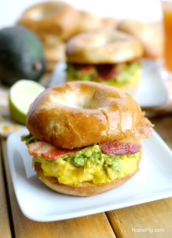 Cheesy Egg Avocado and Bacon Breakfast Sandwich on a white plate.