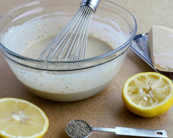Creamy parmesan Salad Dressing in the bowl with a whisk.