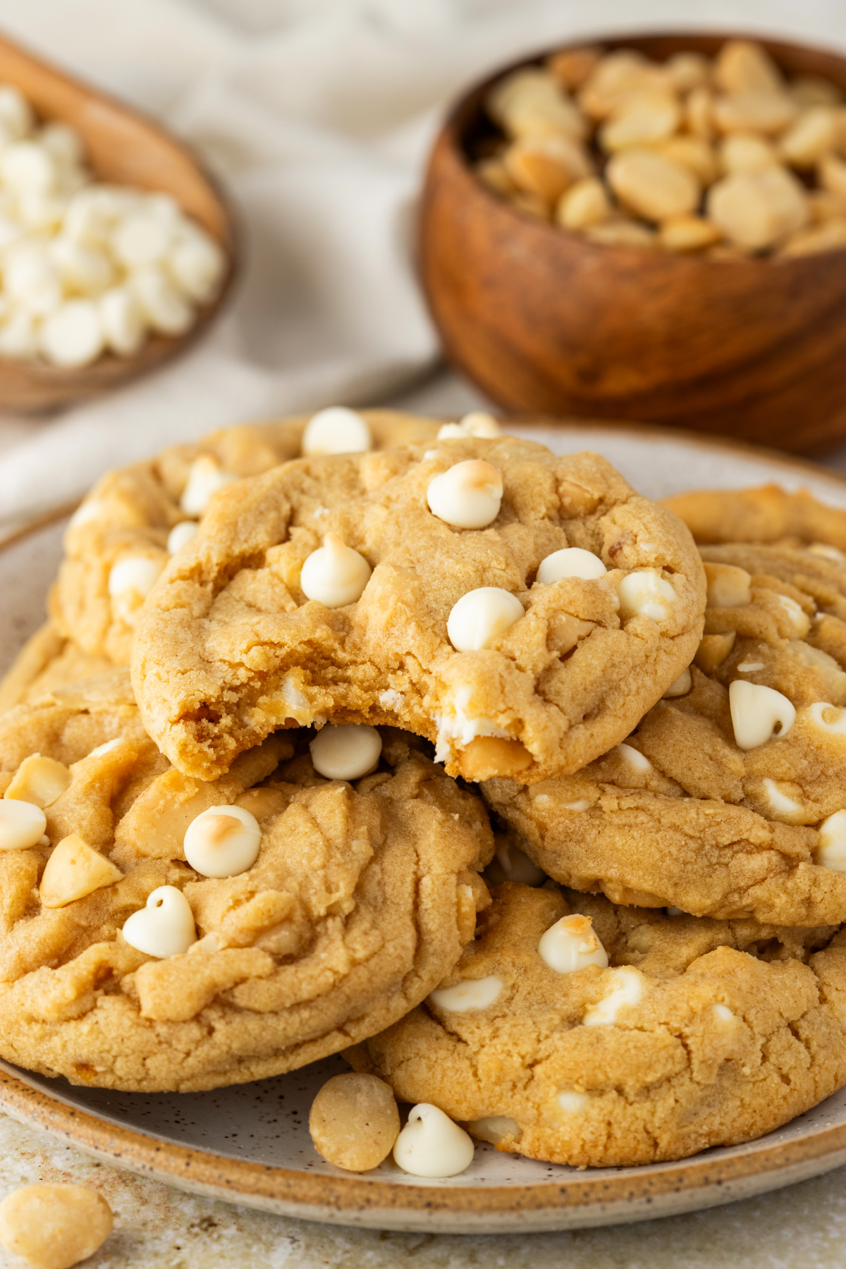 bakery style white chocolate macadamia cookies piled on a plate with soft centers and white chocolate chips