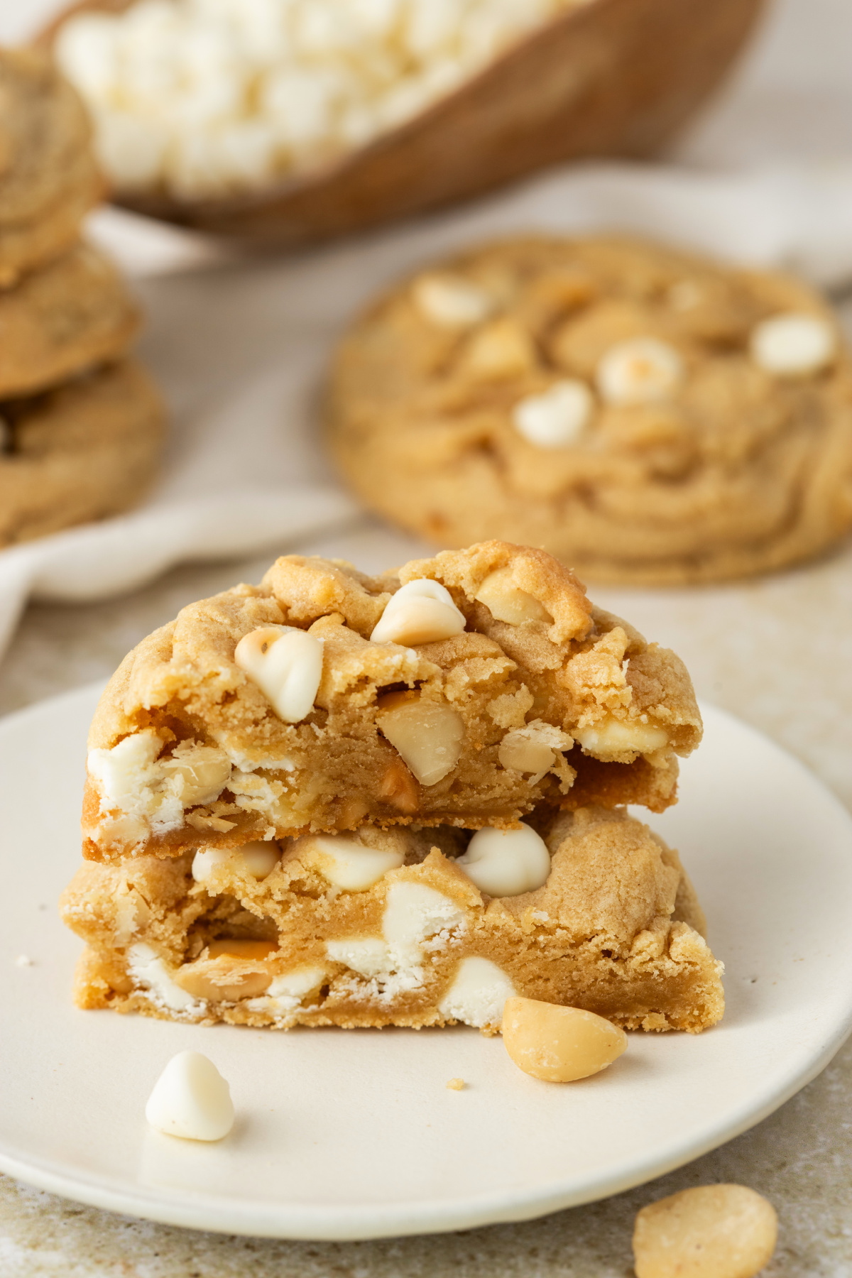 white chocolate macadamia cookie broken open showing soft texture white chocolate chips and macadamia nuts