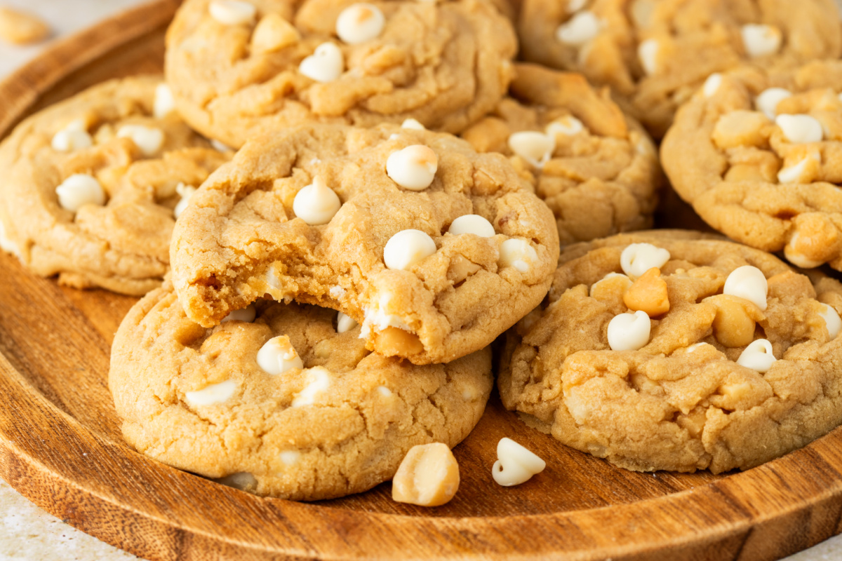 white chocolate macadamia nut cookies with a soft center and a bite showing white chocolate chips and macadamia nuts