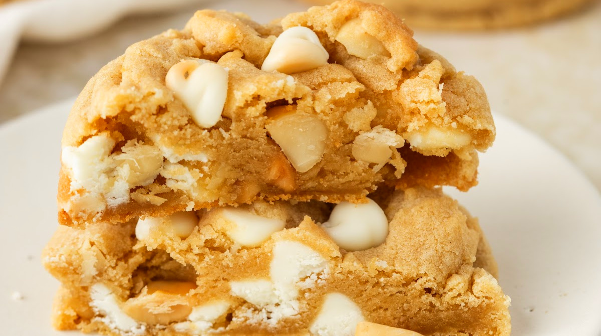 white chocolate macadamia nut cookies stacked thick and soft with white chocolate chips and macadamia nuts