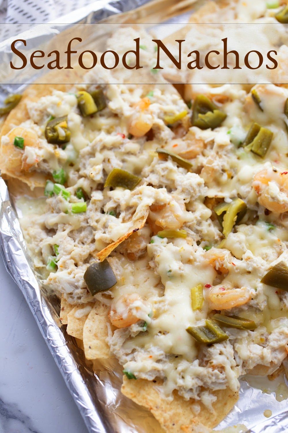 Enhancing the traditional combo of tortilla chips, melted cheese, and pickled jalapenos with shrimp and crab gives these Seafood Nachos a unique flair. They're not just a great pre-dinner but; they can also hold their own as a substantial  meal if needed. This loaded seafood nachos recipe is easy to make and makes great party food. via @cmpollak1
