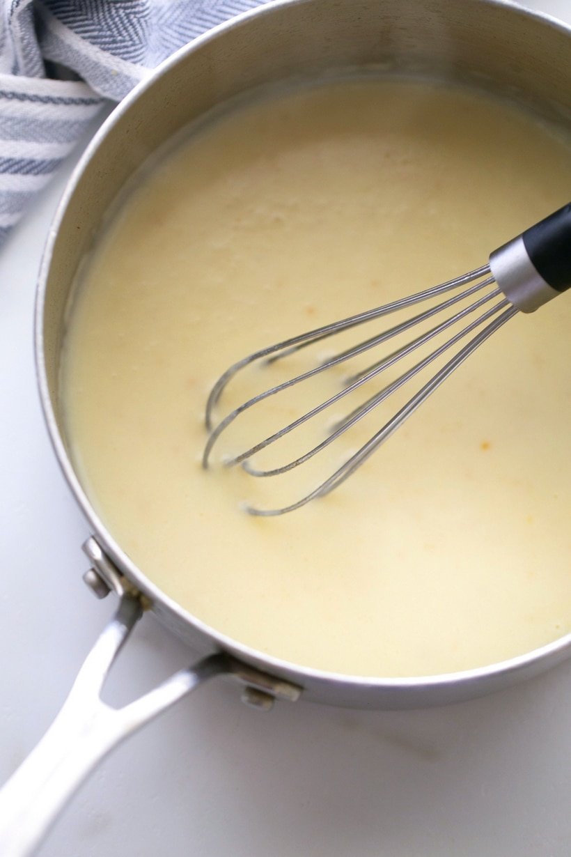 Gnocchi cheese sauce in a pan with a whisk.