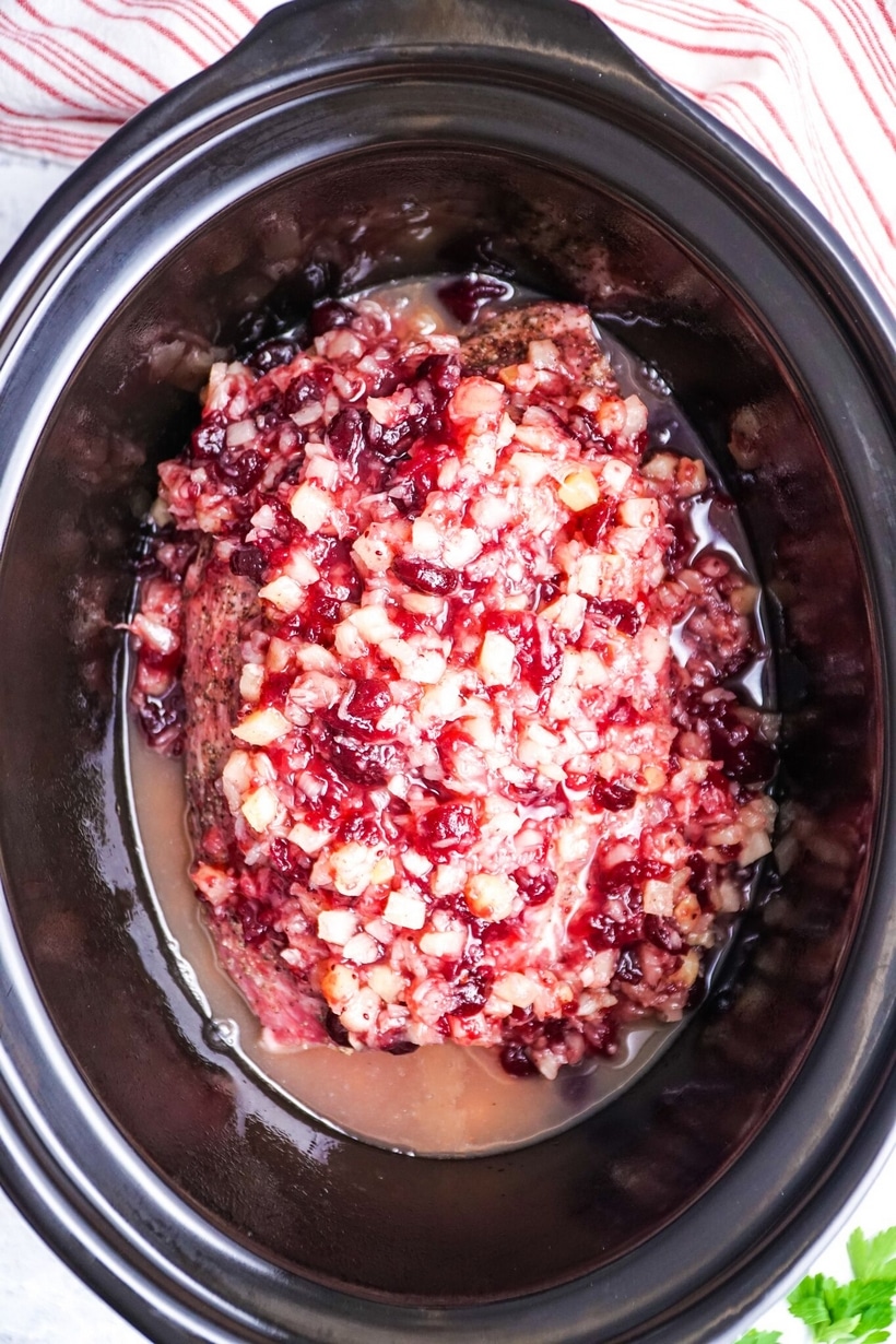 Take the work out of making dinner with this savory and slightly sweet Slow Cooker Pork with Cranberry-Pineapple Sauce. Only five minutes of prep time are needed for this delicious recipe. #slowcooker #slowcookermeal #pork #slowcookerpork #cranberry #pineapple #easyslowcookerrecipe #easyslowcookerrecipes #easydinners #whatsfordinner #dinnerideas #whatshouldimakefordinner #porkroast #pulledpork #cozydinner #whatshouldieat