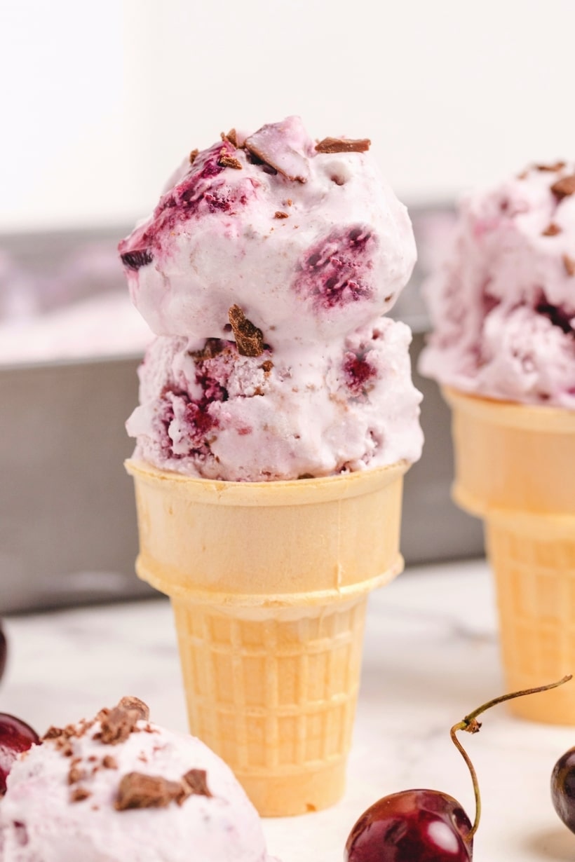Two ice cream cones filled with ice cream.