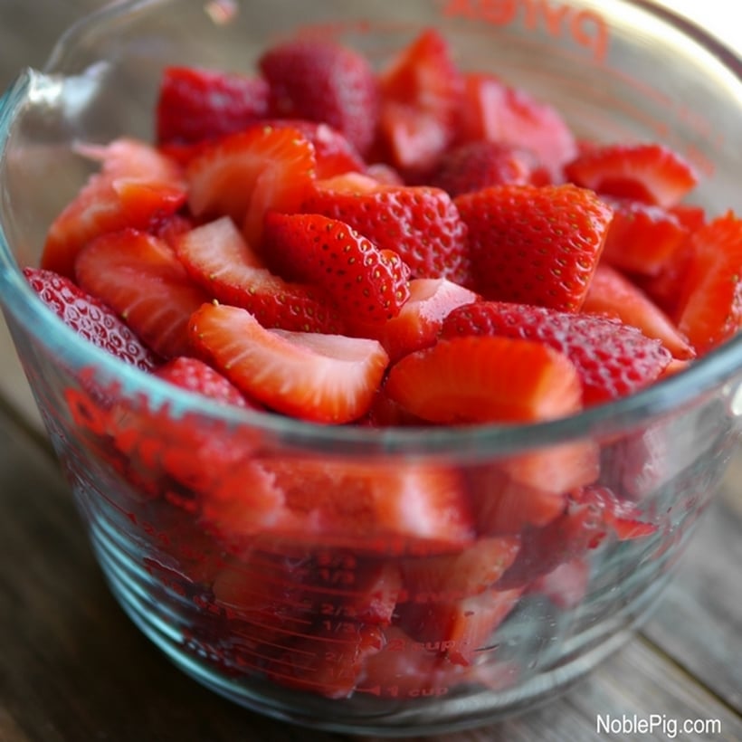 Sliced strawberries in a measuring cup.