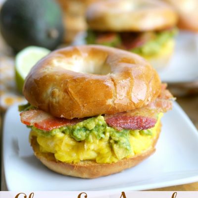 Cheesy Egg Avocado and Bacon Breakfast Sandwich a beautiful way to celebrate the morning on a white plate.