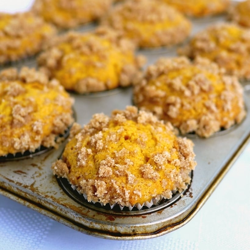 Streuseled Pumpkin Buttermilk Muffins in a muffin tin.