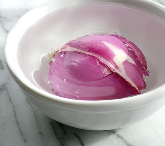 Red onion soaking in a bowl.