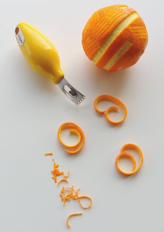 An orange that has been been peeled decoratively with a peeling tool.