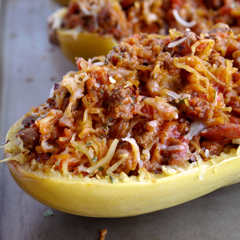 Stuffed Spicy Italian Spaghetti Squash Boats ~ All the flavors of a hearty spaghetti dinner packed into a tender, roasted spaghetti squash. This Stuffed Spicy Italian Spaghetti Squash Boats recipe are the answer to comfort food made in a healthy way.  A fork is all it takes to separate the pale orange strands of the gourd into vegetable noodles. It couldn't be easier from NoblePig.com. #noblepig #spaghettisquash #italianfood #healthyeats