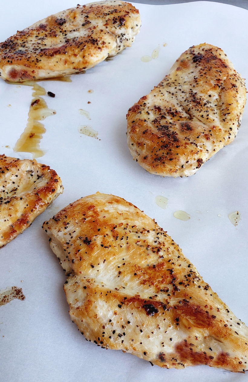 Four cooked chicken breasts.