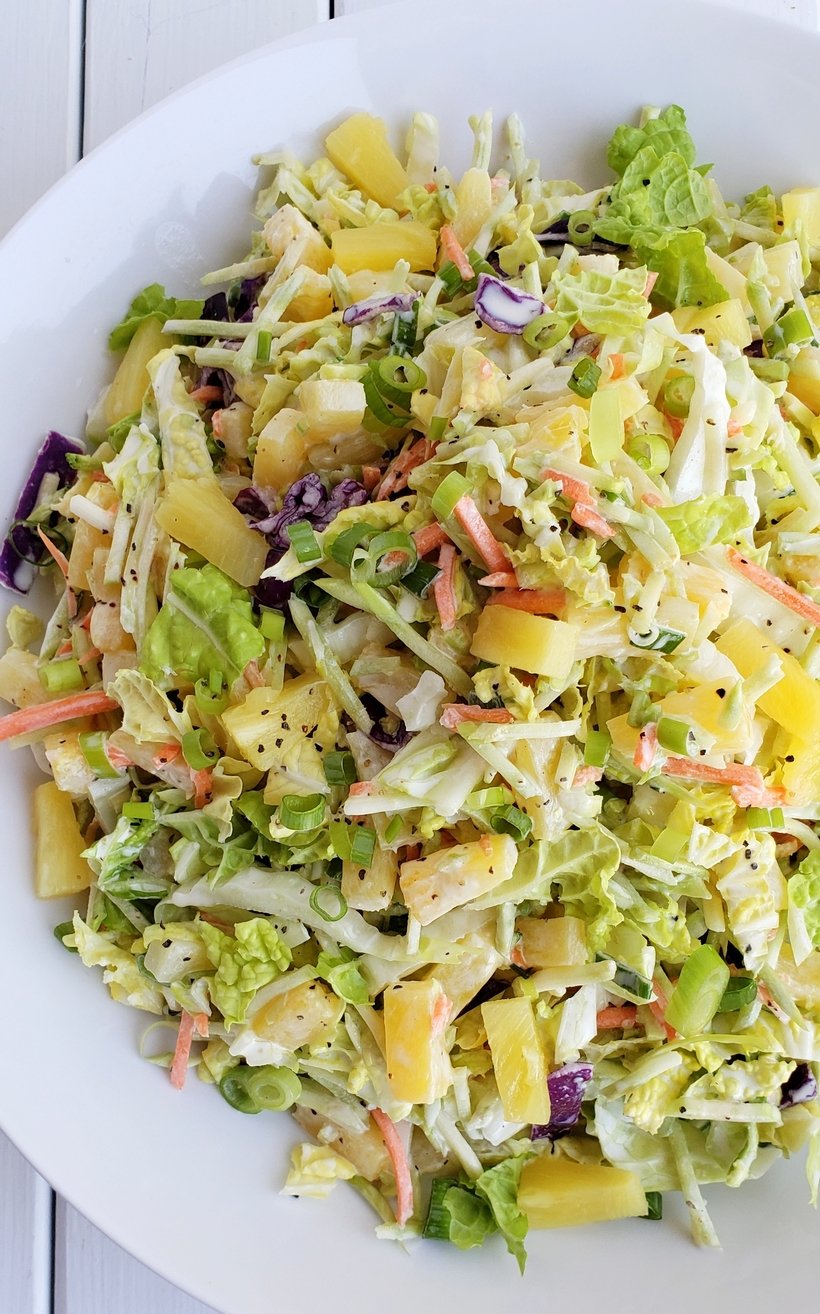 Overhead view of pineapple coleslaw on a white plate.