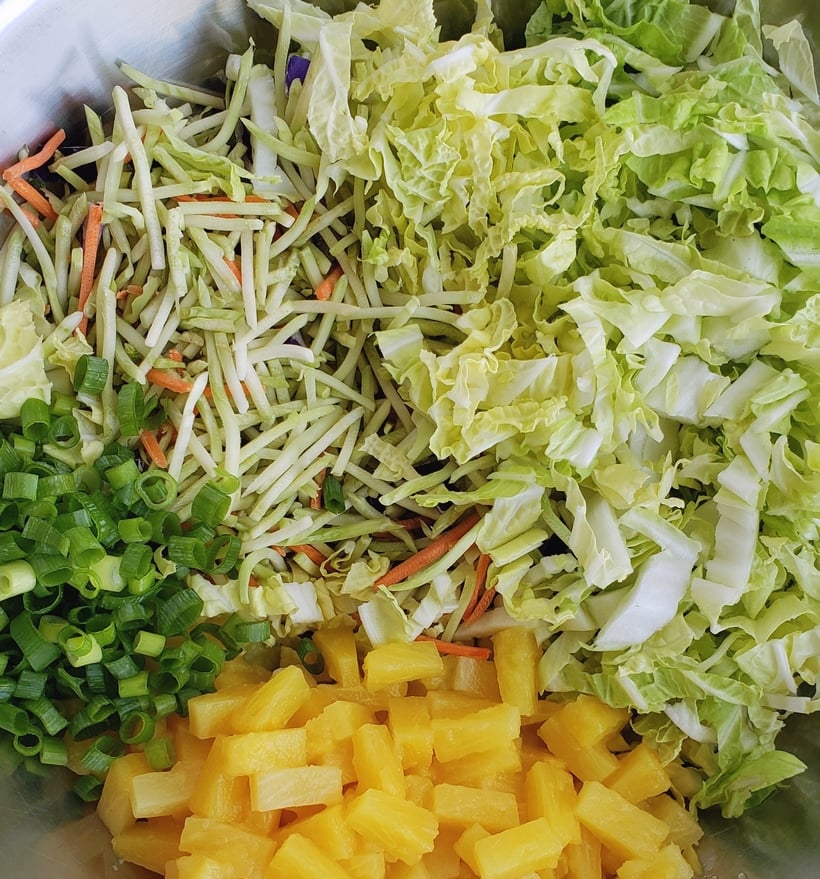 Overhead view of pineapple coleslaw ingredients that are chopped and shredded.