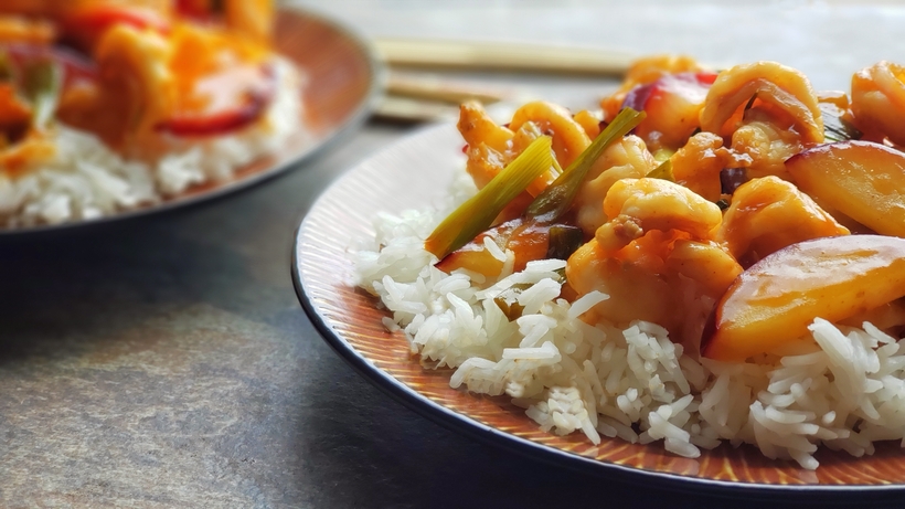 Two plates of shrimp stir-fry on brown plates.