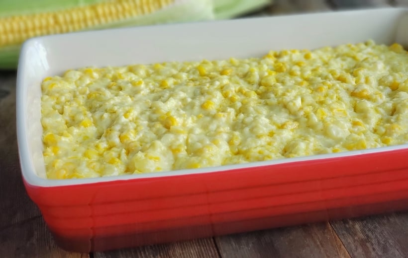 Fresh corn mixture in a red serving dish before baking.