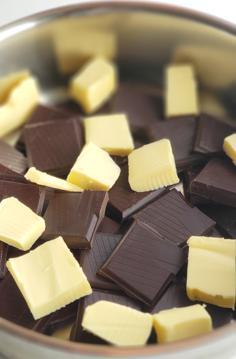 Squares of chocolate and cubes of butter in a saucepan.
