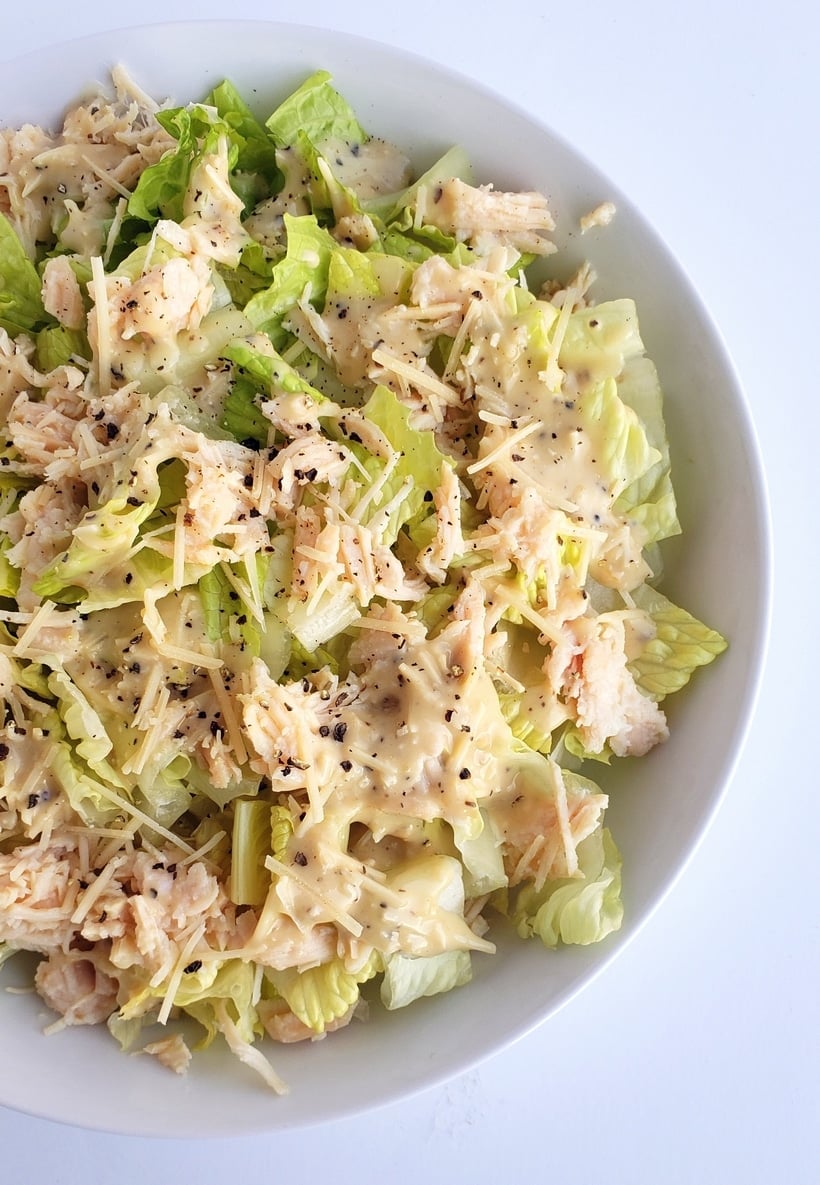 A bowl of canned chicken Caesar salad.