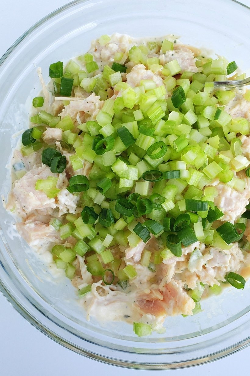 Canned chicken, green onions and celery in a bowl.