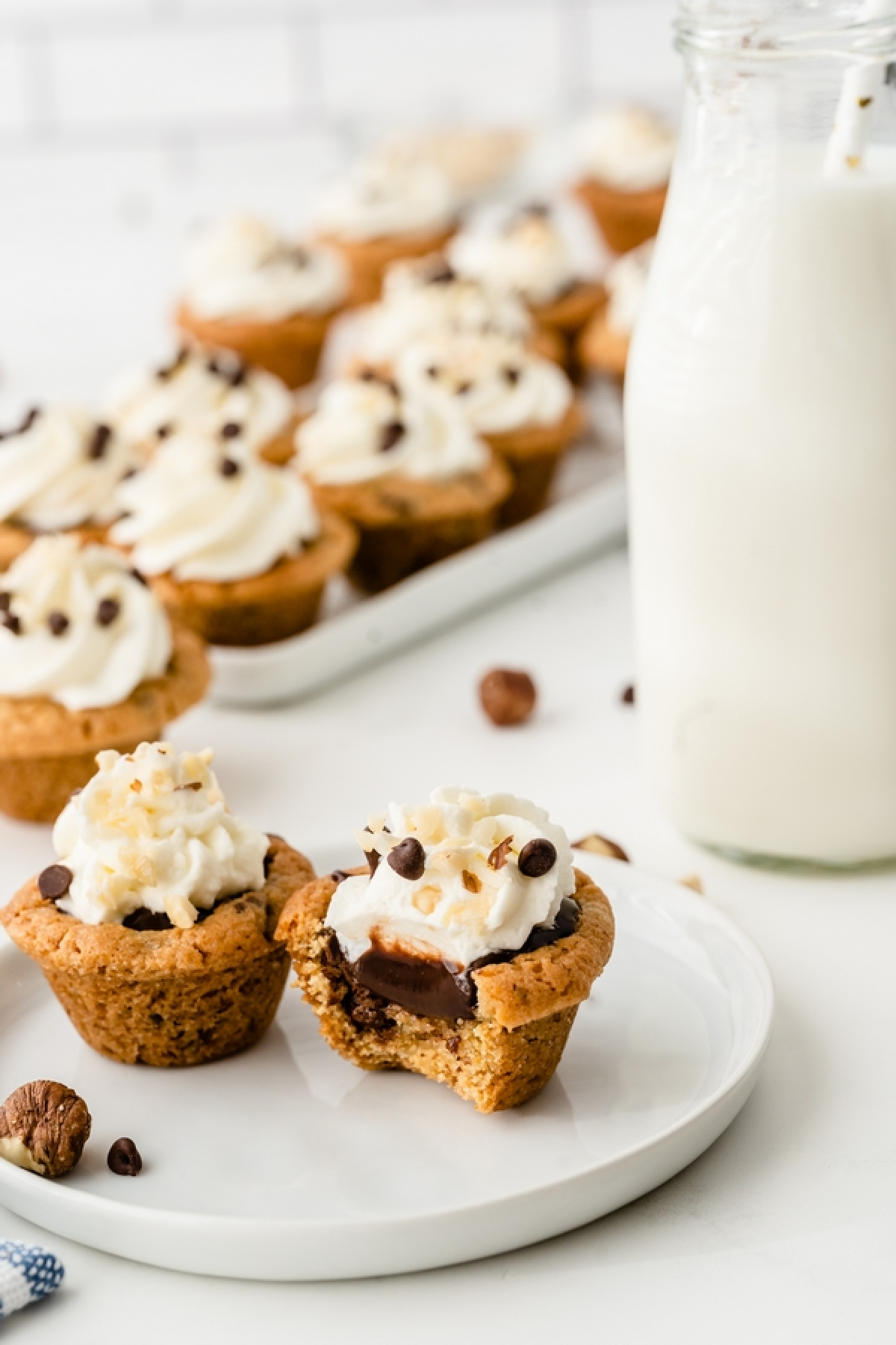 Chocolate chip cookie cups with Nutella filling and whipped cream on a dessert plate