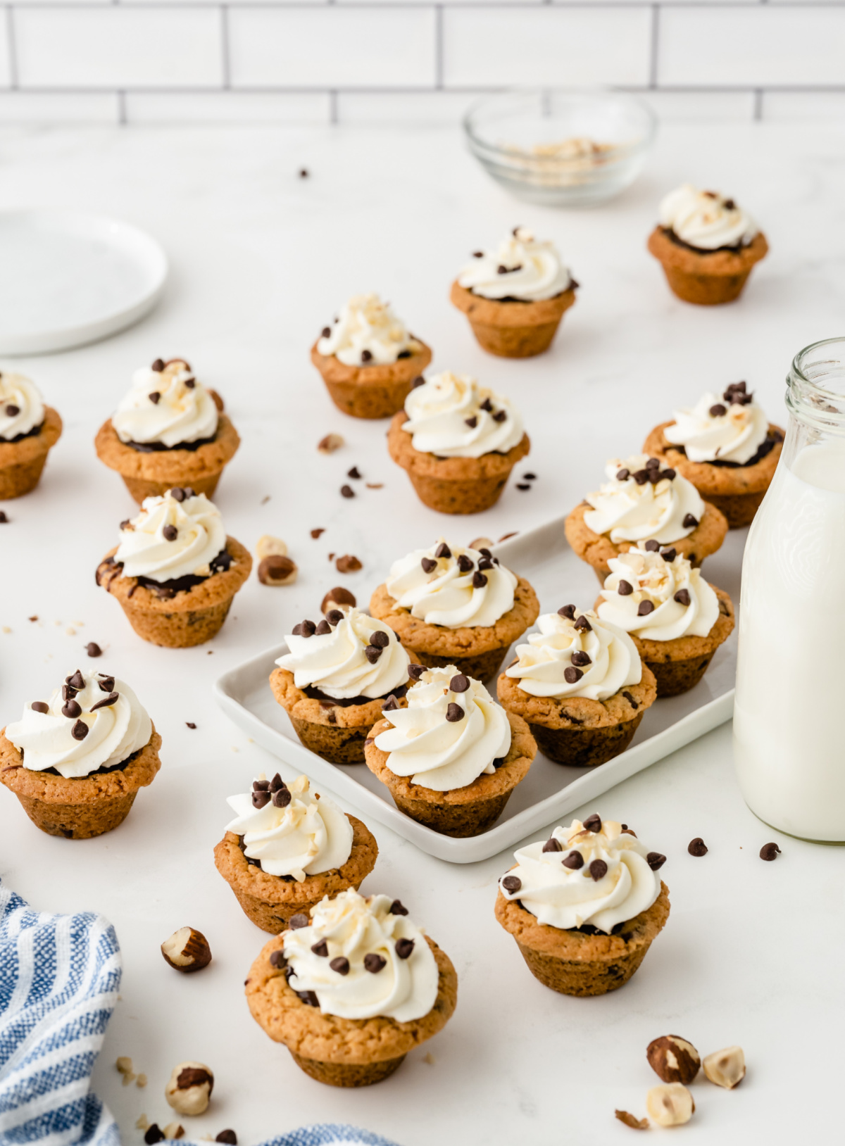 Nutella chocolate cookie cups topped with whipped cream and mini chocolate chips on a serving platter