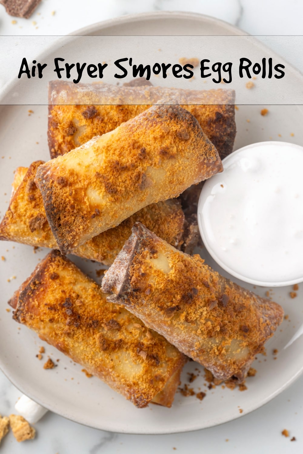 Air-fried and crispy on the outside, these s'mores egg rolls are filled with melted chocolate and marshmallows on the inside, with extra marshmallow fluff served on the outside to dunk into. The perfect twist on a campfire treat. via @cmpollak1