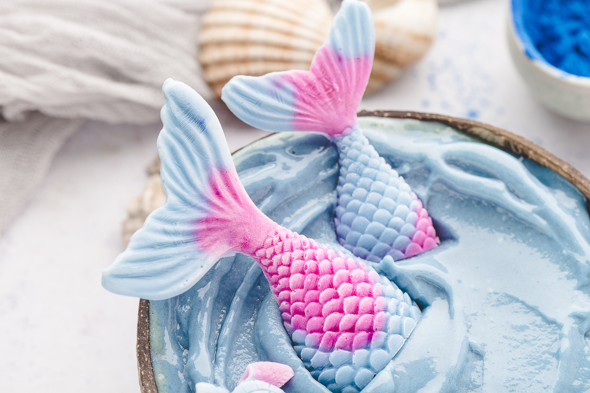 Close-up of homemade yogurt mermaid tails decorating a blue mermaid smoothie bowl.