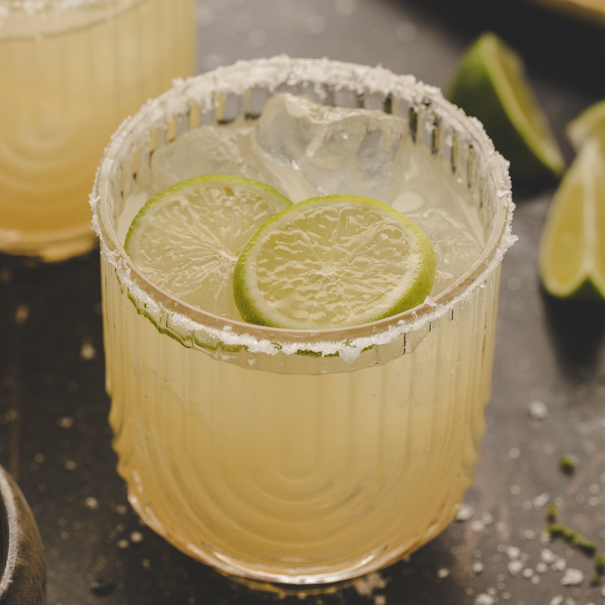 mezcal margarita recipe with salted rim and lime slices in rocks glass