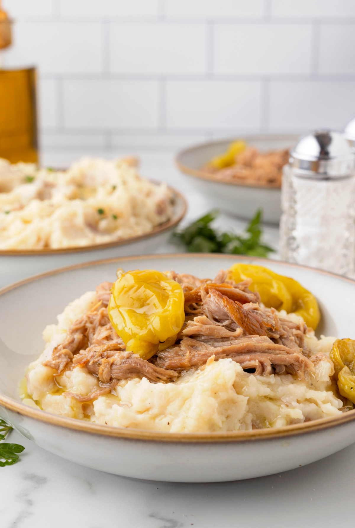Mississippi Pork Roast Served Over Mashed Potatoes Slow cooker Mississippi pork roast shredded over mashed potatoes with whole pepperoncini peppers and seasoned cooking liquid.