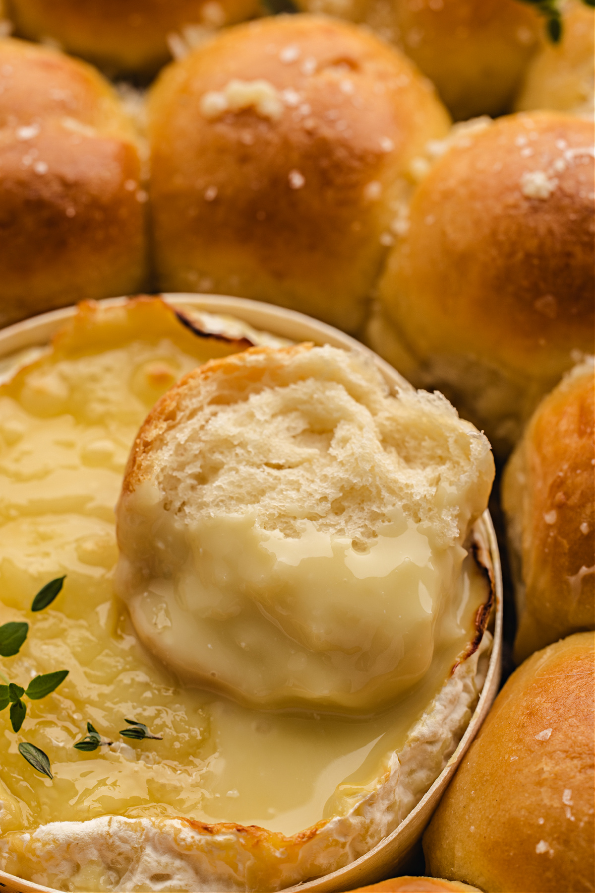 A tender roll dipped into the melted Camembert, coated in warm cheese.