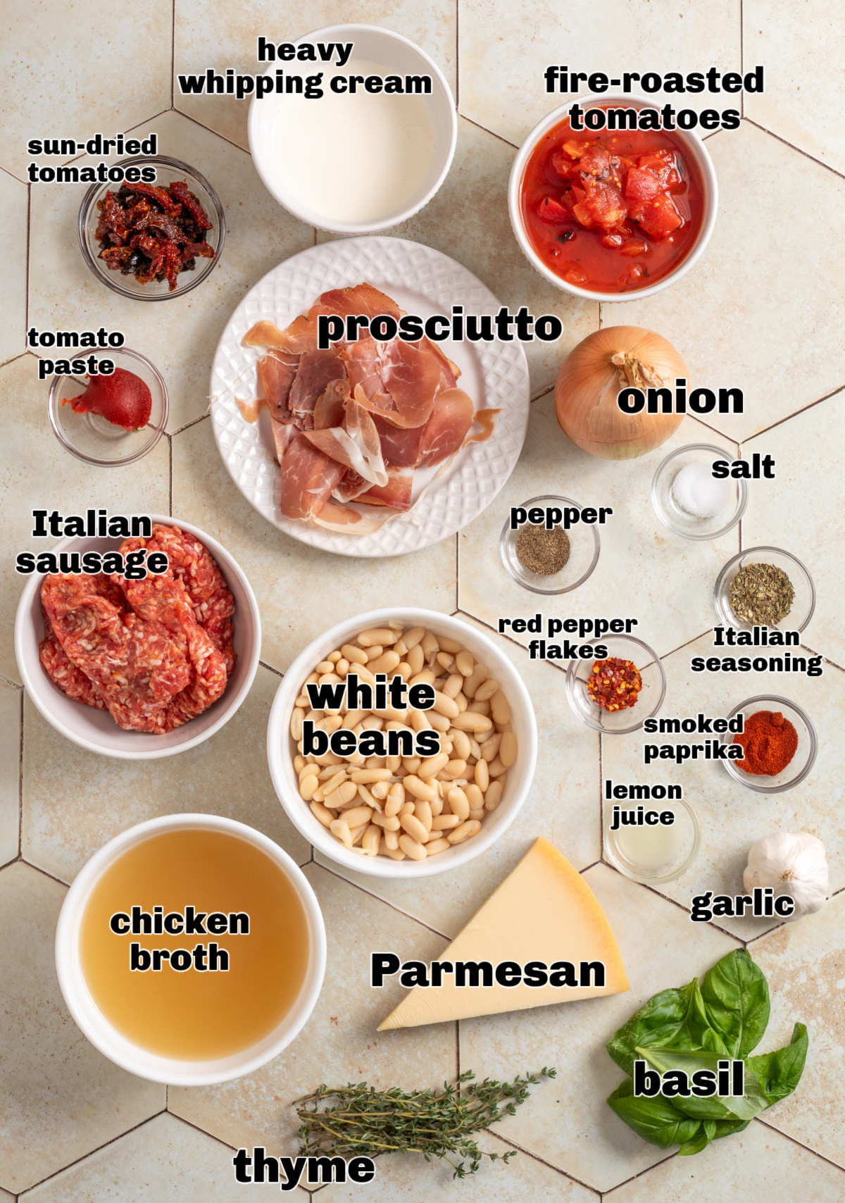 Marry Me White Bean and Sausage Soup ingredients arranged on tile, including Italian sausage, white beans, prosciutto, Parmesan, herbs, lemon, and sun-dried tomatoes.