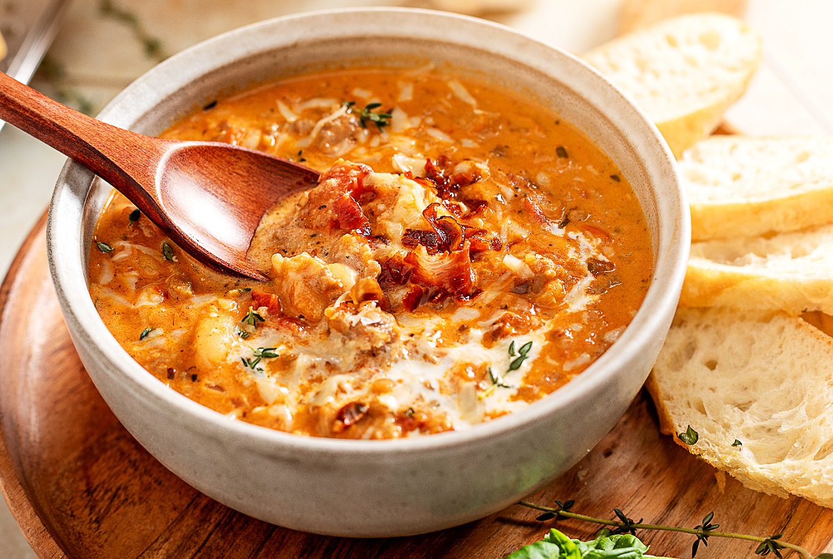 Marry Me White Bean and Sausage Soup by Noble Pig, creamy Tuscan soup with Italian sausage, white beans, and prosciutto served with crusty bread slices.