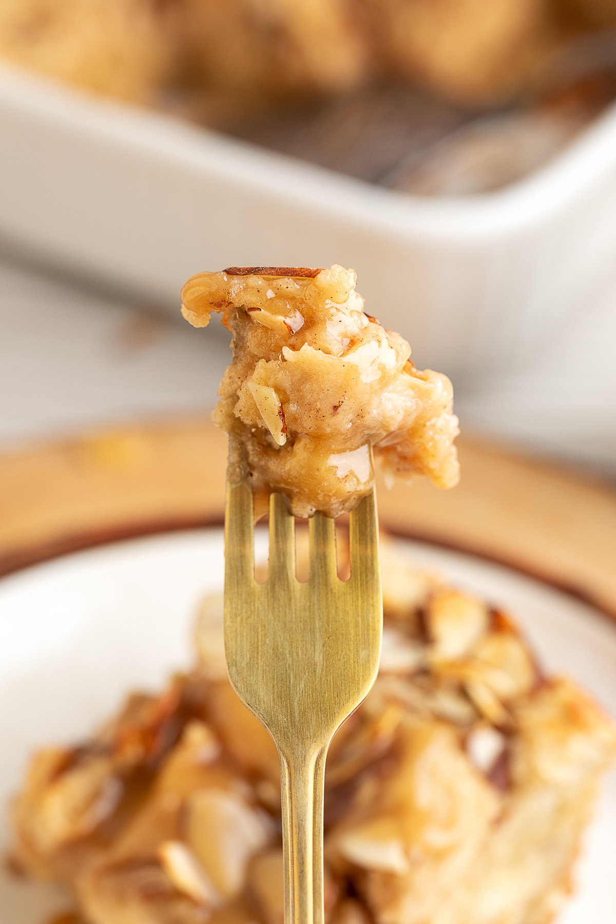 a bite of almond bread pudding on a fork. a forkful of almond bread pudding with marzipan