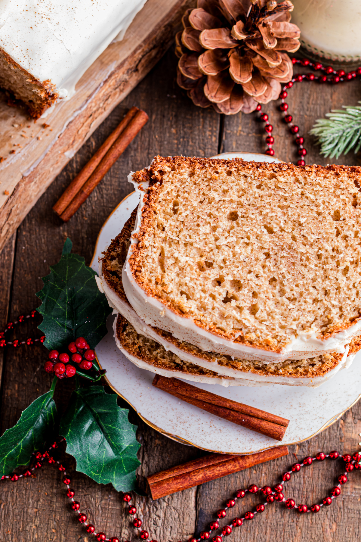 Close-up of sliced eggnog bread with a set eggnog glaze, highlighting the tender crumb and warm spice throughout the loaf.