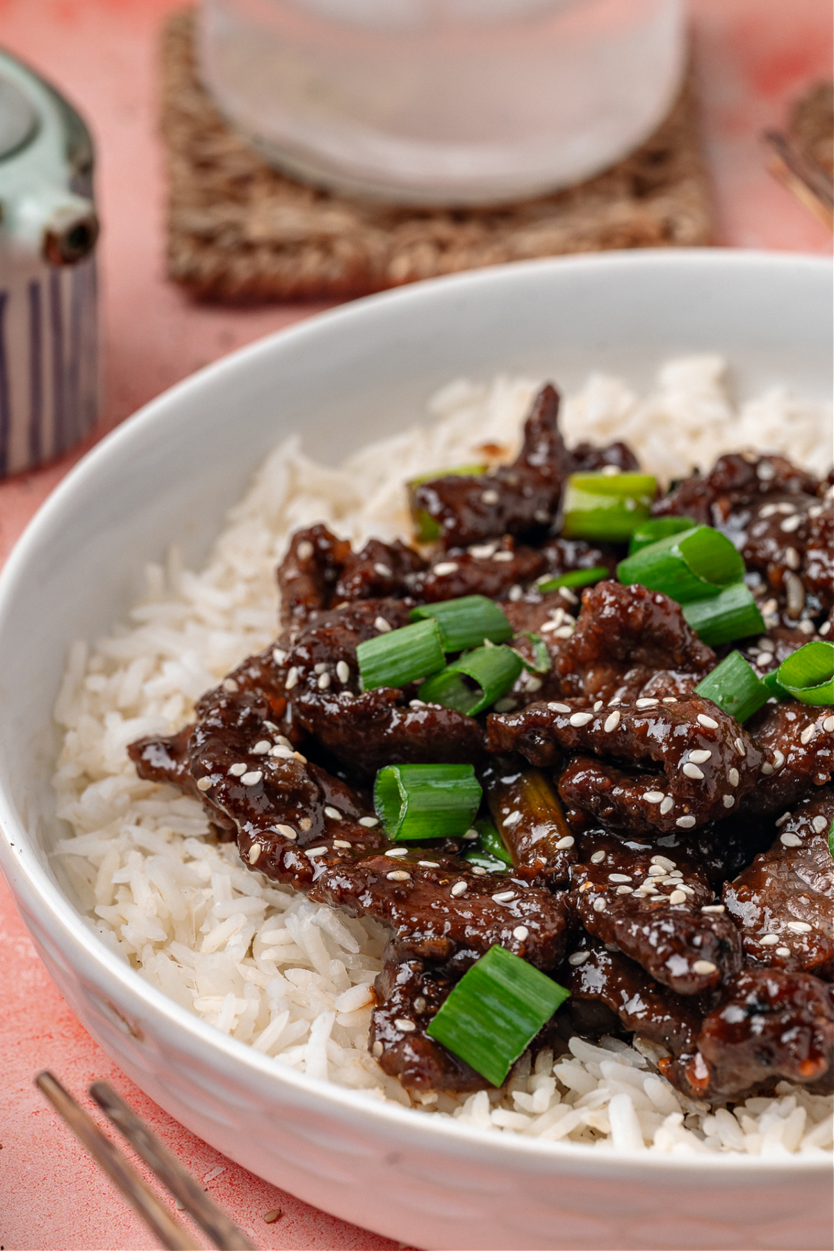 Tender slices of soy glazed beef served over white rice with sliced green onions and sesame seeds.