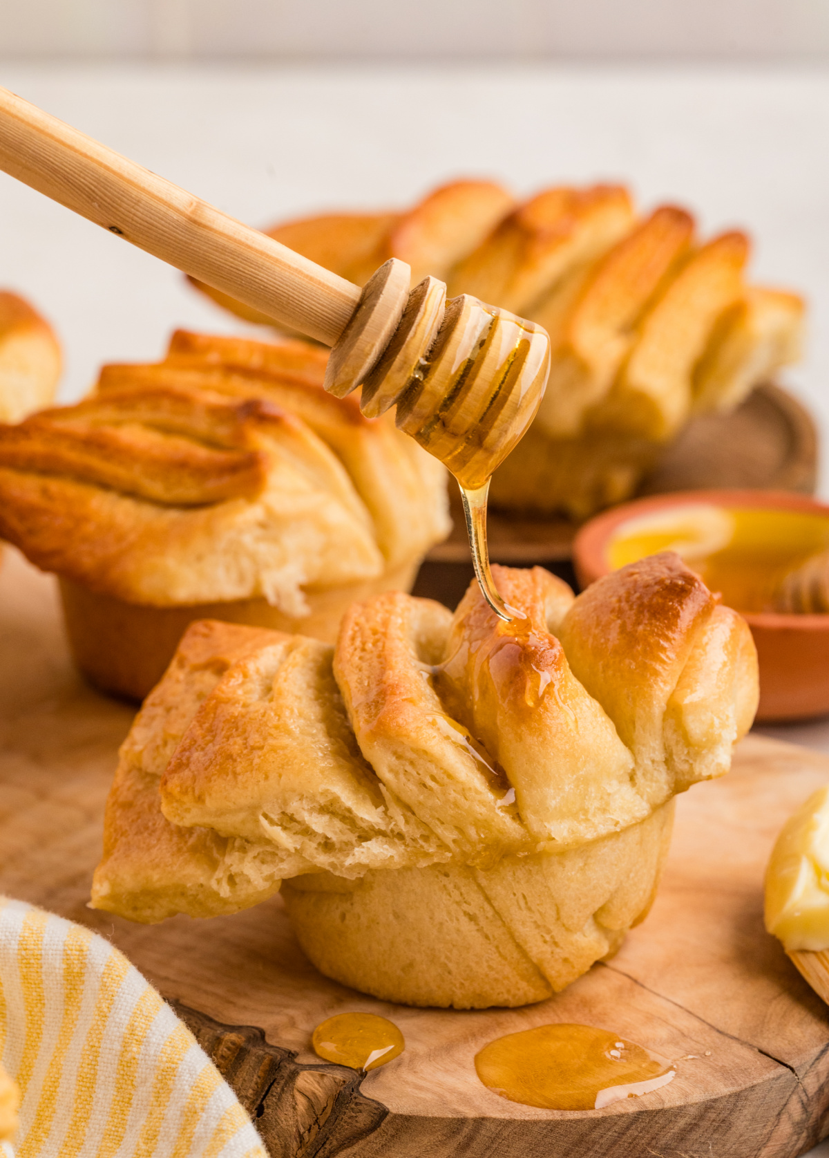 Honey butter pull-apart rolls drizzled with honey, showing soft layered folds and a tender interior.