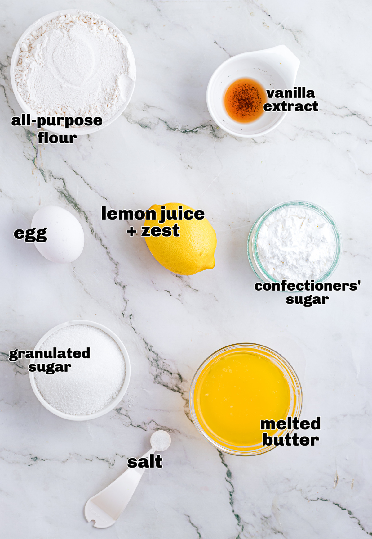 Ingredients for lemon dessert bars arranged on a marble surface, including flour, sugar, melted butter, egg, lemon, vanilla extract, salt, and confectioners&rsquo; sugar.