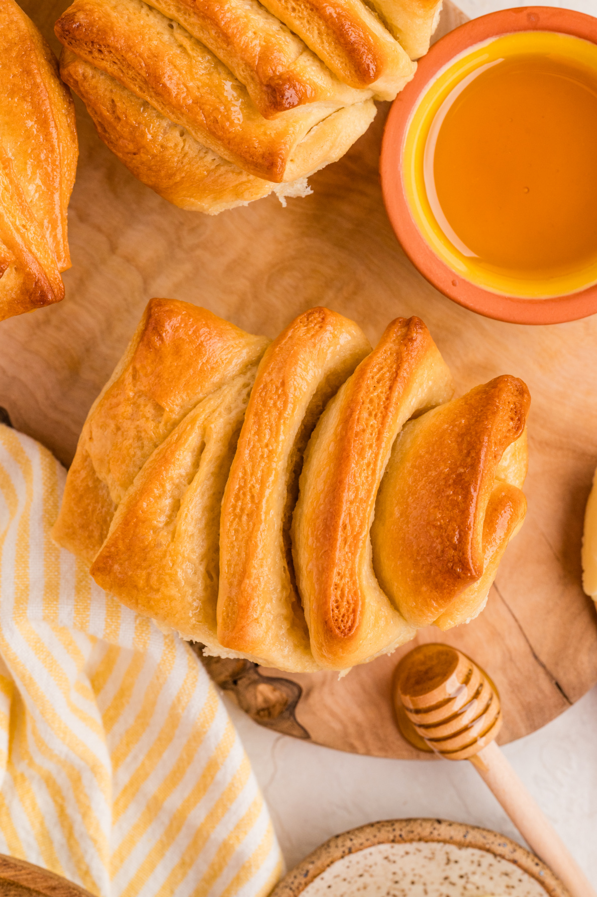 Overhead of pull-apart rolls with honey and butter.
