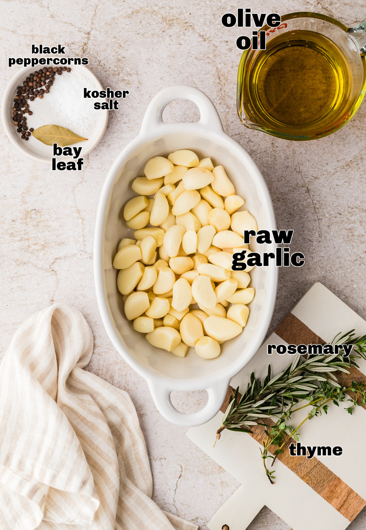 Peeled raw garlic cloves with olive oil, thyme, rosemary, bay leaf, kosher salt, and black peppercorns.