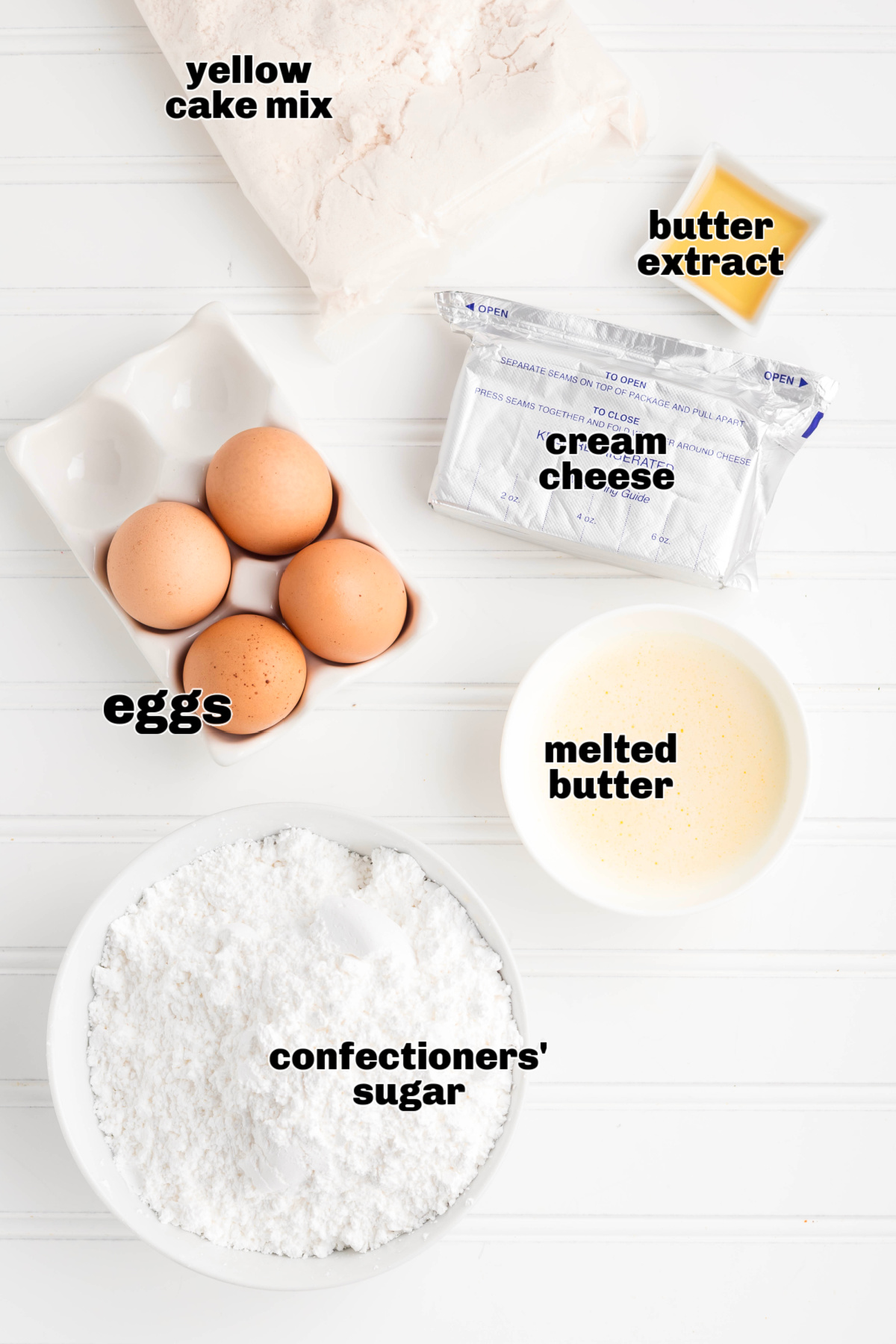 Ingredients for a classic cream cheese butter cake including yellow cake mix, cream cheese, eggs, melted butter, butter extract, and confectioners&rsquo; sugar.
