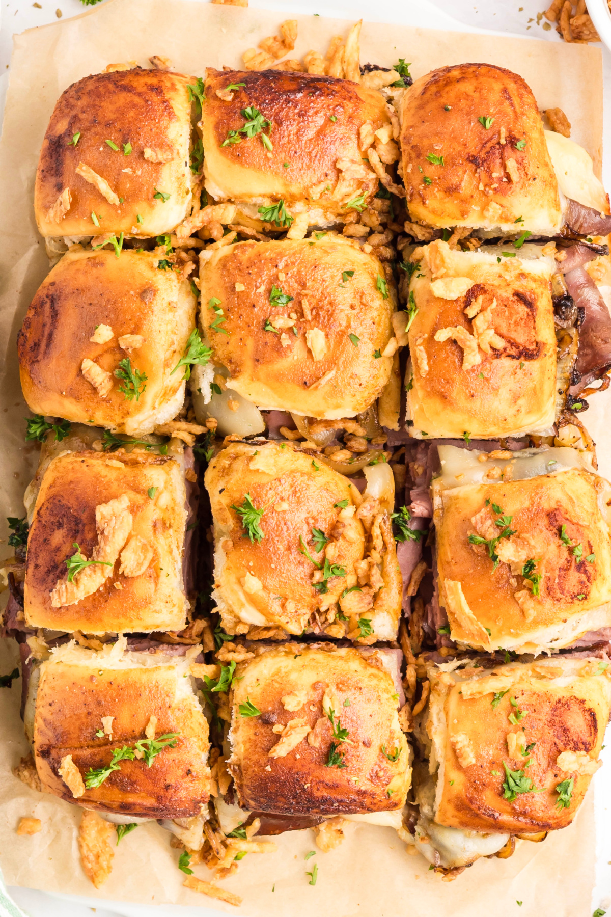 Pull-apart roast beef sliders baked on sweet rolls with melted provolone and caramelized onions