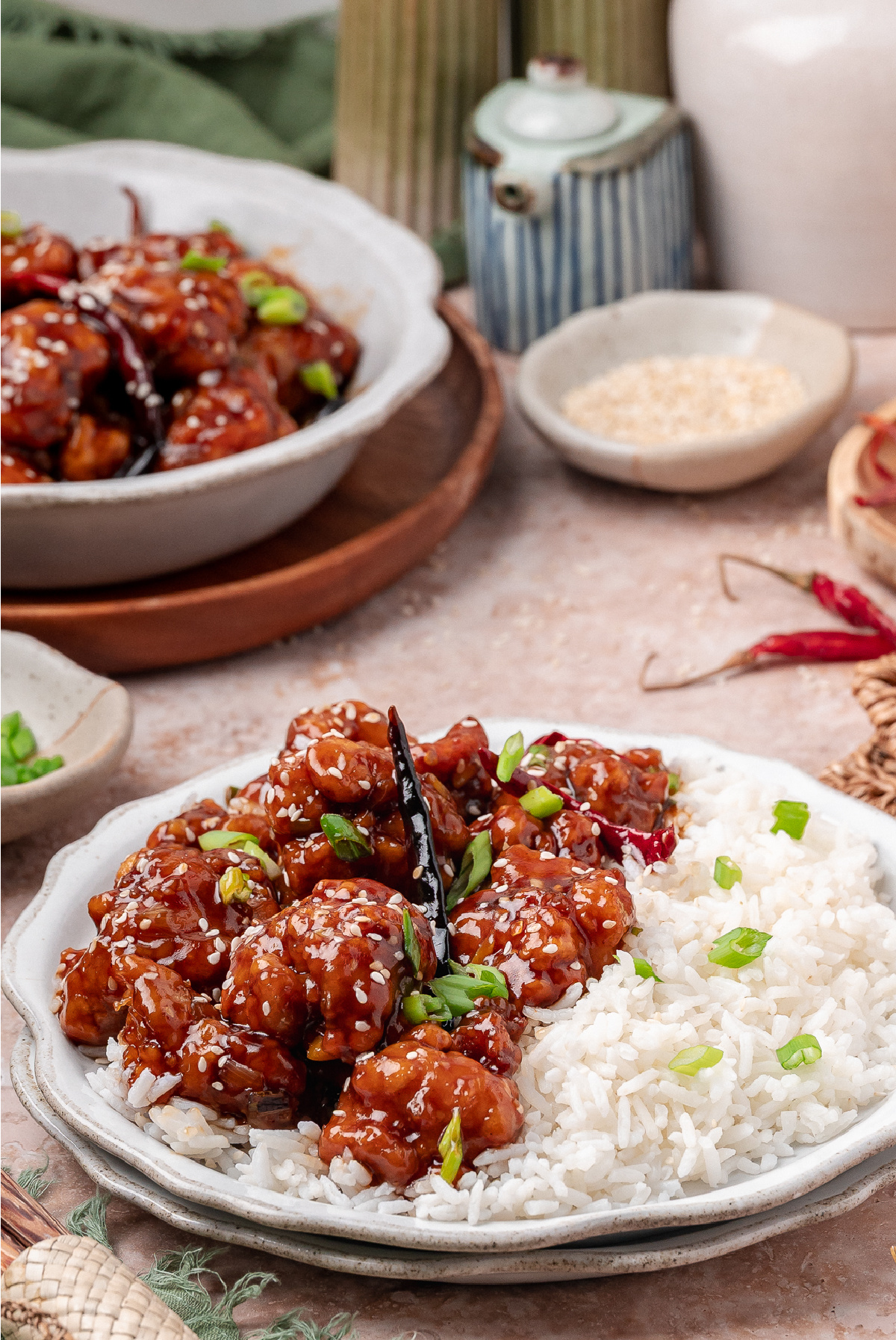 General Tso&rsquo;s chicken served over white rice with scallions, sesame seeds, and dried chilies