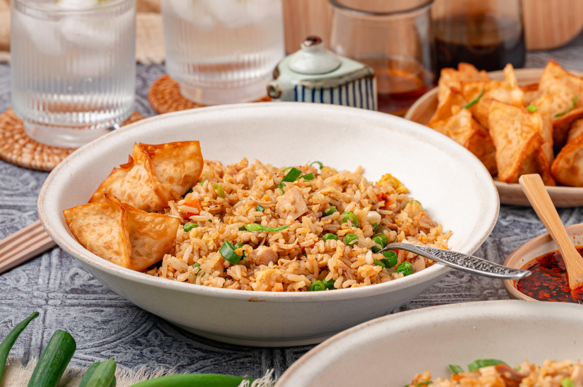 Chicken fried rice served in a bowl with crispy wontons and green onions