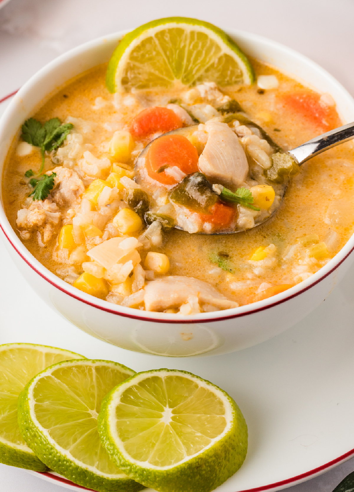 Creamy Chicken and Rice Poblano Soup with corn, carrots, and fresh lime slices