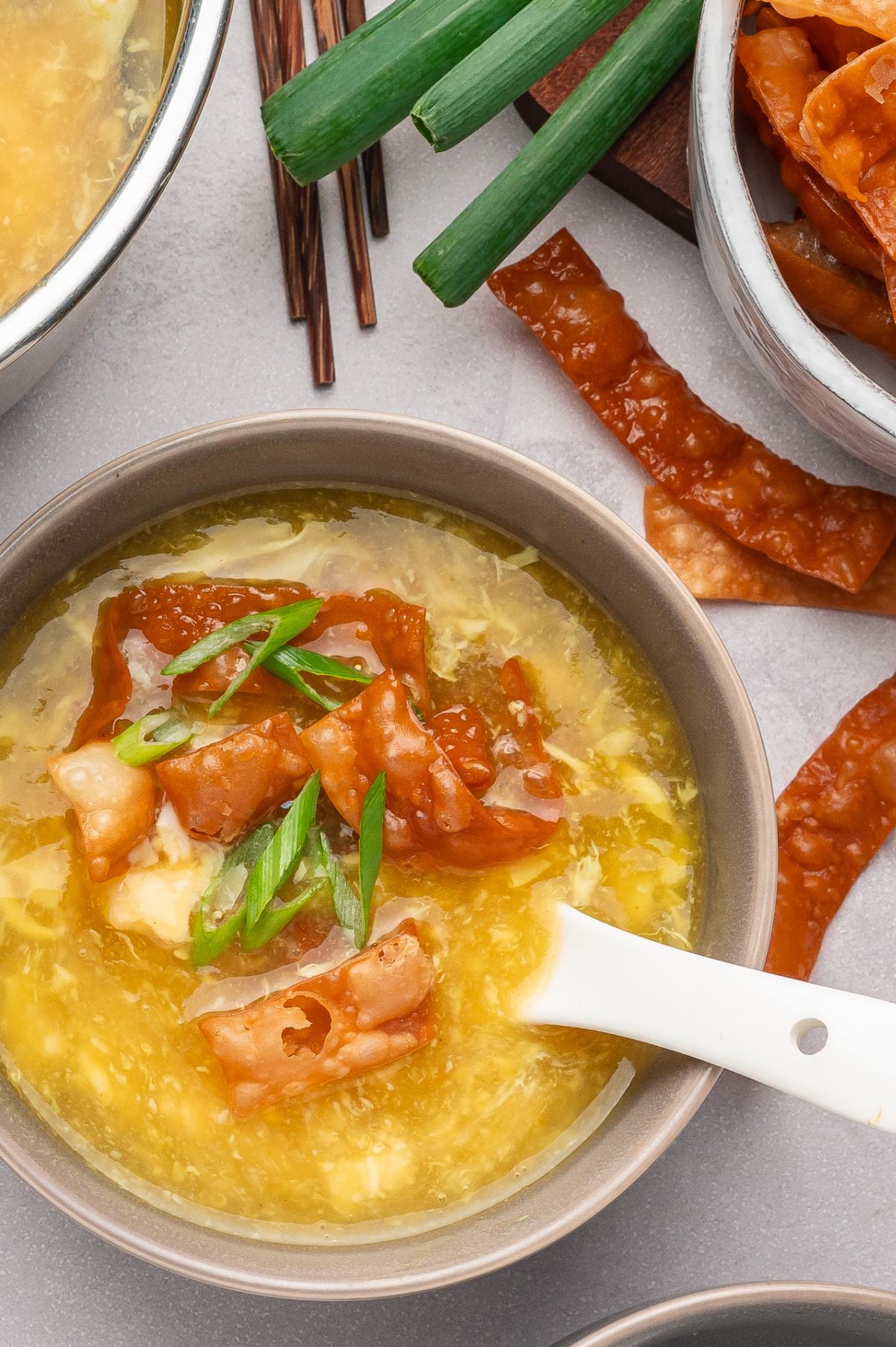 Egg drop soup with crispy fried wonton strips and green onions