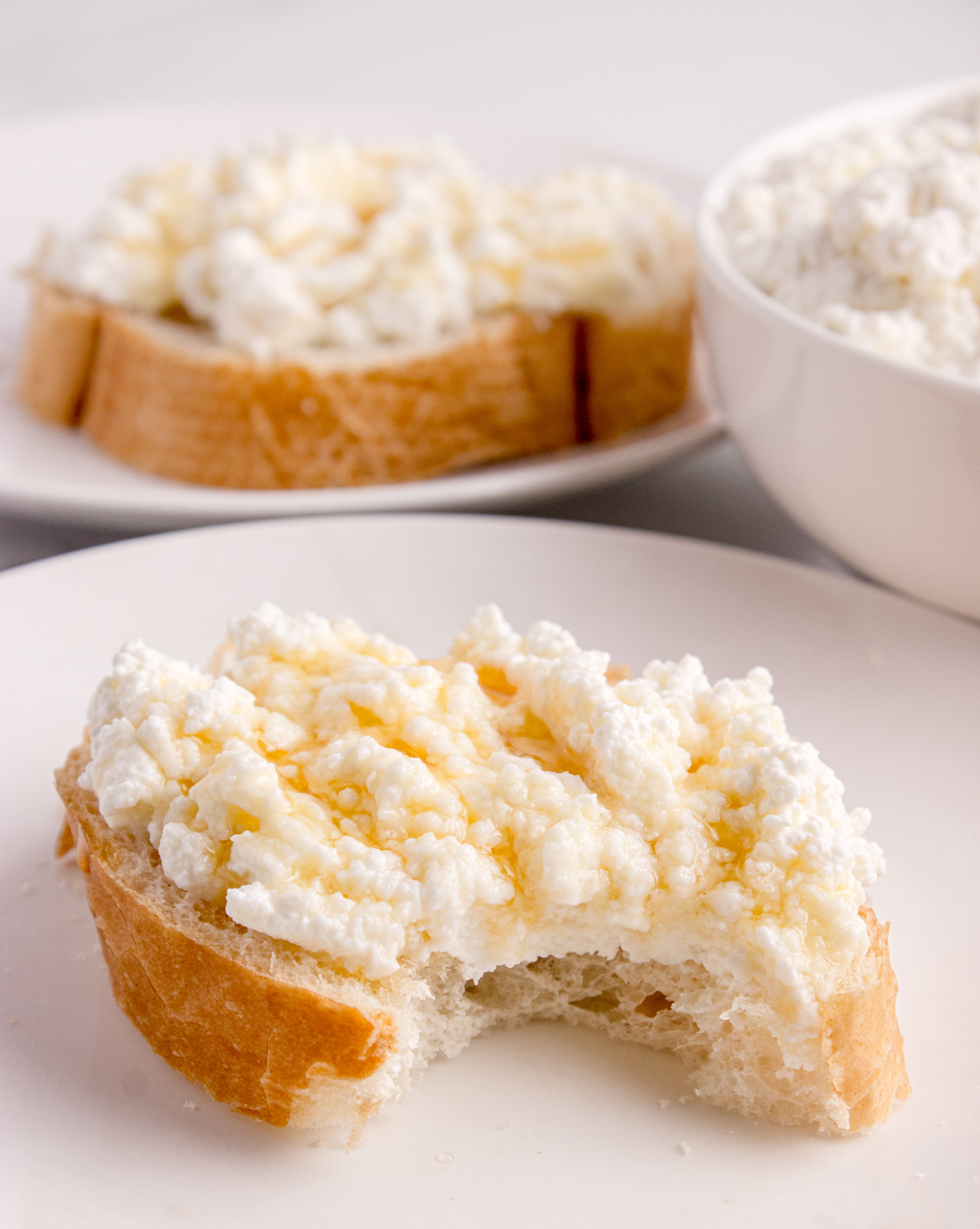 Fresh ricotta spread on bread with a bite taken out